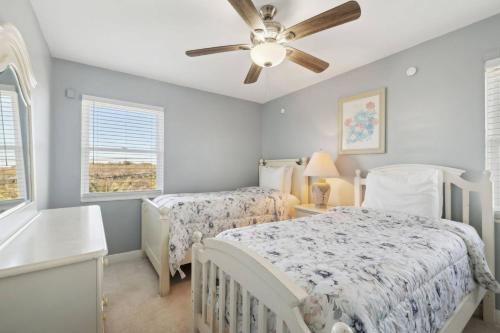 Un dormitorio con dos camas y un ventilador de techo. en The Beach Bum, en Ponte Vedra Beach