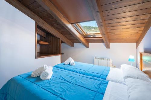 a bedroom with two beds with blue and white sheets at Apartamento Casa el Cojo 2c in Alcalá de la Selva