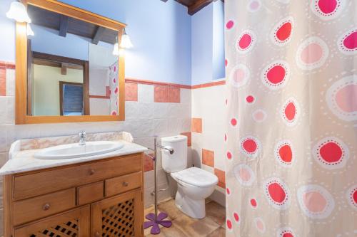 a bathroom with a toilet and a sink and a mirror at Apartamento Casa el Cojo 2c in Alcalá de la Selva