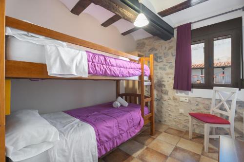 a bedroom with two bunk beds and a chair at Apartamento Casa El Cojo 2a in Alcalá de la Selva