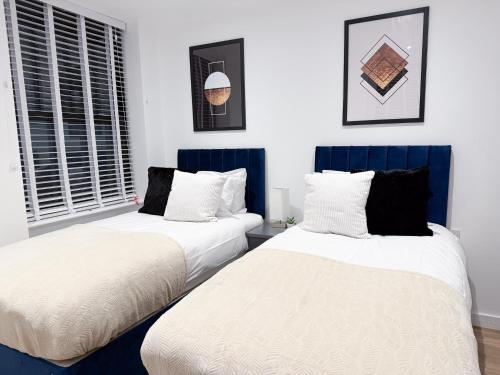 two beds sitting next to each other in a bedroom at Spacious Modern 1 Bed Apartments in St Neots - Perfect for Contractors & Professionals - Free Parking - WiFi - Fully Equipped Kitchen - Smart TV Ideal for Work Stays and Long Projects in Saint Neots