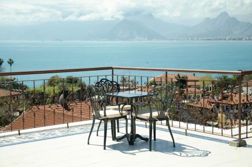 a table and chairs on a balcony overlooking the water at Patron Hotel in Antalya