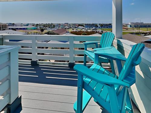 two blue chairs on a deck with a view of the ocean at Port As Flip Flops & Pop Tops in Port Aransas