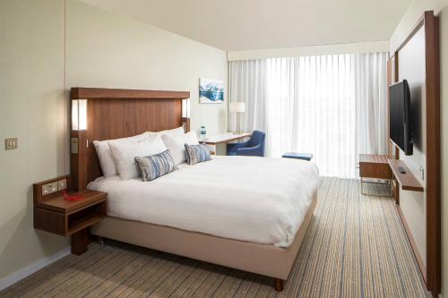 a hotel room with a large bed and a television at Courtyard by Marriott Inverness Airport in Inverness