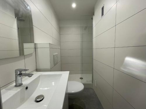 une salle de bain blanche avec un lavabo et des toilettes dans l'établissement Bel appartement au coeur de la presqu'île de Giens, avec parking, à Hyères