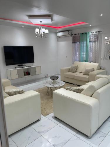 salon z białymi meblami i telewizorem z płaskim ekranem w obiekcie Renaissance w mieście Dakar