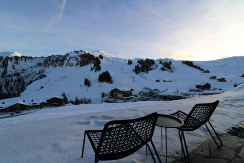 two chairs and a table on top of a snowy mountain at Appartement ski in-out 4-6 pers Les Crosets Porte du Soleil in Les Crosets