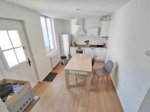 une cuisine avec une table et des chaises dans une pièce dans l'établissement L'Alexiane, Centre Luchon, parking gratuit, wifi, à Luchon