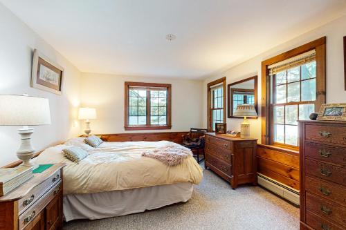 a bedroom with a bed and a dresser and windows at Moose & Red Fox Retreat in Denmark