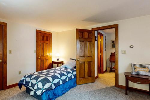 a bedroom with a bed and an open door at Moose & Red Fox Retreat in Denmark