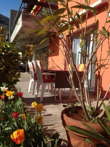 a table and chairs outside of a house with flowers at Al Colombajo in Intragna