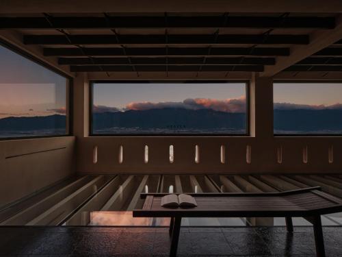 a room with a bench and two windows at 大理空岛半山海景民宿 in Dali