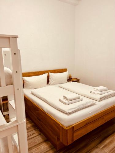 a bed with white sheets and a ladder in a room at Apartments La Rosa in Rust