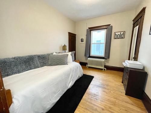 a bedroom with a white bed and a window at Charming Centrally Located Duplex with Parking in Minneapolis