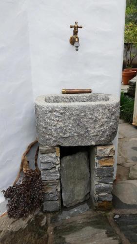 a stone sink with a faucet on a wall at Casa San Cristoforo Atelier in Maggia
