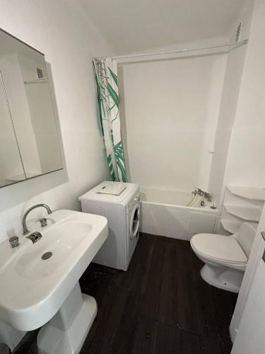 une salle de bain blanche avec un lavabo et des toilettes dans l'établissement LIDO Juan les pins - Front de mer, à Antibes