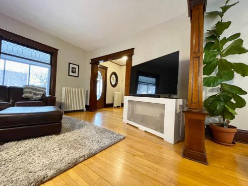 a living room with a couch and a television at Charming Centrally Located Duplex with Parking in Minneapolis