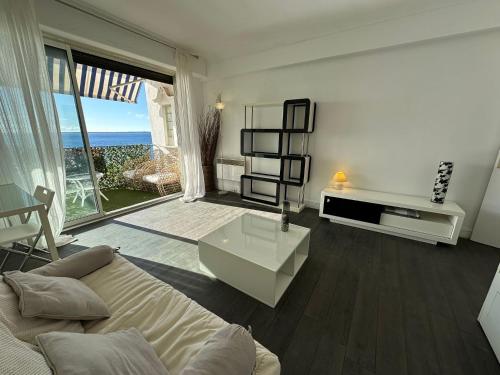 un salon avec un canapé et une vue sur l'océan dans l'établissement LIDO Juan les pins - Front de mer, à Antibes