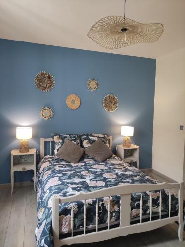 - une chambre bleue avec un lit et deux lampes dans l'établissement Le Kaki végétal, à Montluçon