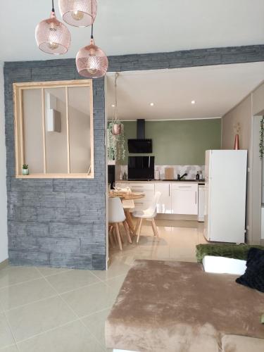 Il dispose d'une cuisine et d'un salon avec un mur en briques. dans l'établissement Le Kaki végétal, à Montluçon