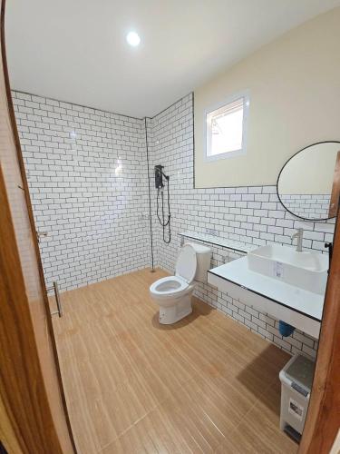 a bathroom with a toilet and a sink at น่านสุขใจ รีสอร์ท in Sa