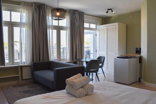 a hotel room with a bed and a couch and a table at NEW Roof terrace apartment in Jordaan Area in Amsterdam