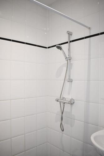 a shower in a white tiled bathroom with a sink at NEW Roof terrace apartment in Jordaan Area in Amsterdam