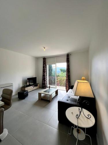 un salon avec un canapé et une table dans l'établissement Le Kiwi, bel appartement moderne en pleine nature, à Hyères