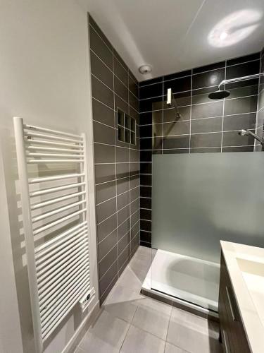 une salle de bain avec une douche, un lavabo et une baignoire dans l'établissement Le Kiwi, bel appartement moderne en pleine nature, à Hyères