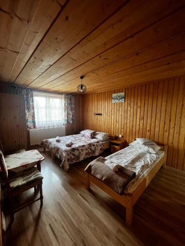 a bedroom with two beds in a wooden room at ,, U Nikoli" in Bukowina Tatrzańska