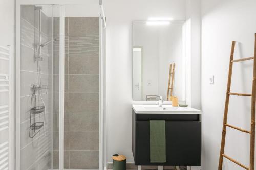 une salle de bain avec un lavabo et une douche dans l'établissement Charmante maison Angoulins, à Angoulins-sur-Mer