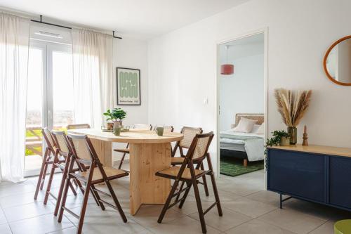 une cuisine et une salle à manger avec une table et des chaises en bois dans l'établissement Charmante maison Angoulins, à Angoulins-sur-Mer