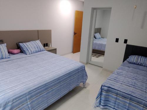 une chambre avec deux lits et un miroir dans l'établissement Nosso Recanto 2 Próximo aos Pontos Turísticos, à Foz do Iguaçu