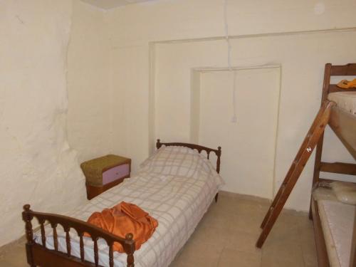 a small bedroom with a bed and a ladder at Σπίτι Monemvasia Kritsas - κάτω από τη - Ροδάνθη in Kritsá