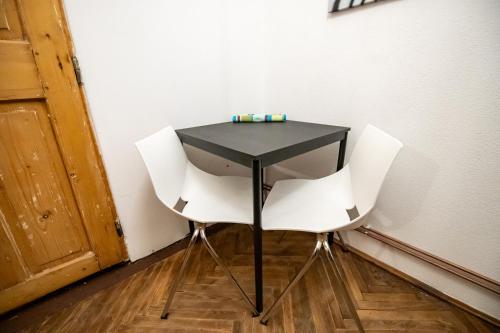 a black table and two white chairs in a room at Altius Studio 2 in Braşov
