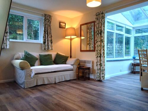 a living room with a couch and a window at Waterwitch Cottage in Newquay
