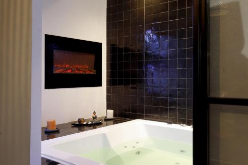 a bath tub in a bathroom with a fireplace at Sweet Namaste - Host Provence in Mandelieu-la-Napoule