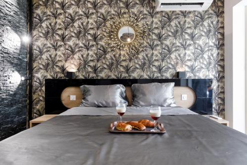 a bed with a tray of food and two glasses of wine at Sweet Namaste - Host Provence in Mandelieu-la-Napoule