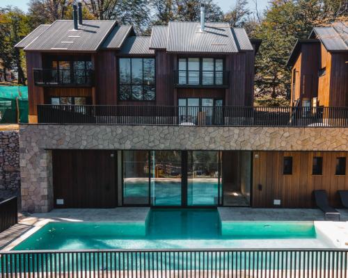 ein Haus mit einem Swimmingpool davor in der Unterkunft RentUp - Las mejores vistas de San Martin, Volcan Lanin Chapelco y Lago Lacar in San Martín de los Andes