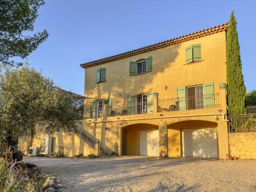 a large yellow house with a staircase in front of it at Vendange Tardive in Flayosc