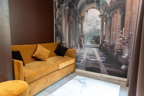 a couch in a room with a painting on the wall at Adelaide Suite Dreams in Rome