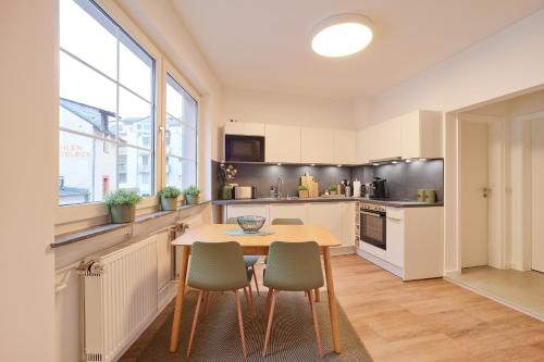 a kitchen with a wooden table and chairs at NEU - Stilvolle & zentrale Ferienwohnung mit Komfort in Wittlich - Zentrum - 4 Personen - 2 Schlafzimmer - Netflix - Waschmaschine in Wittlich