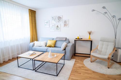 a living room with a blue couch and a table at EXPO-Basel-CH Apt, Amazon Prime Video, WiFi, Coffee & Tee, Popcorn, Kitchen in Basel