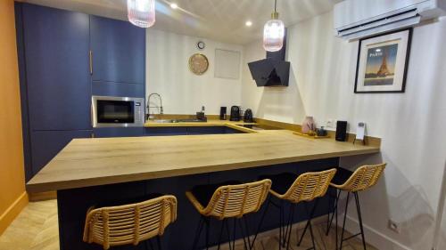 une cuisine avec un comptoir et des chaises autour de la cuisine dans l'établissement Appartement Fontainebleau, à Boissettes