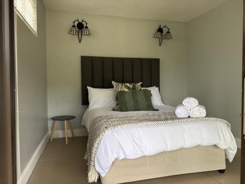 a bedroom with a large bed with a black headboard at Aspire on Meier in East London