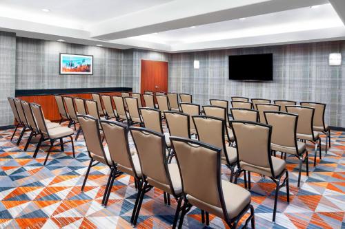 a conference room with chairs and a flat screen tv at Courtyard Scottsdale North in Scottsdale