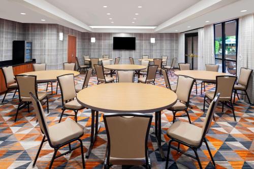 a conference room with tables and chairs and a screen at Courtyard Scottsdale North in Scottsdale