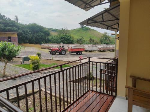 a house with a balcony with a tractor in a parking lot at Residencial do Chocolate - CECAB in Guadalupe