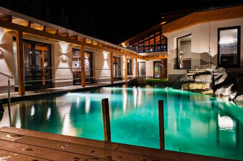 a swimming pool in front of a building at night at Hotel Horal in Rožnov pod Radhoštěm