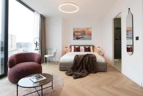 a bedroom with a bed and a chair and a table at LevelUp Amsterdam in Amsterdam